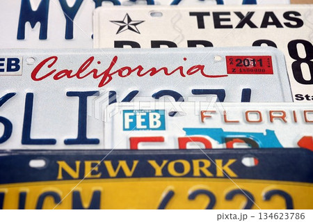 Old US car license plates with various state names close up. Concept of driving in United States. Reaching a car registration 134623786