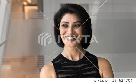Headshot of Armenian businesswoman looks away with optimistic, joyful expression Headshot of Armenian businesswoman looks away with optimistic, joyful expression 134624704
