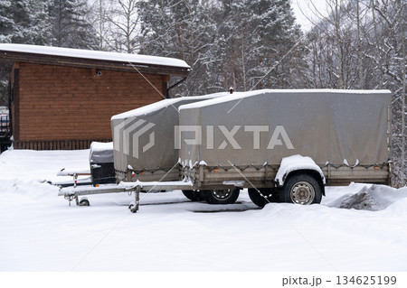 Car trailers in a snowy parking lot in the forest in winter. Car trailers in a snowy parking lot in the forest in winter. 134625199