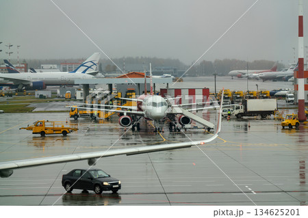 An airplane at the airport with boarding ramps. 134625201