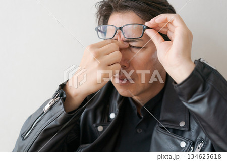 目頭を押さえる50代男性 134625618