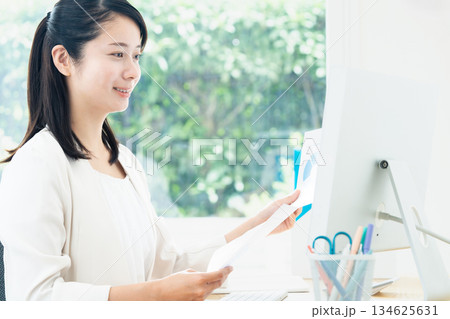 パソコンで資料作成する若い女性 パソコンで資料作成する若い女性 134625631