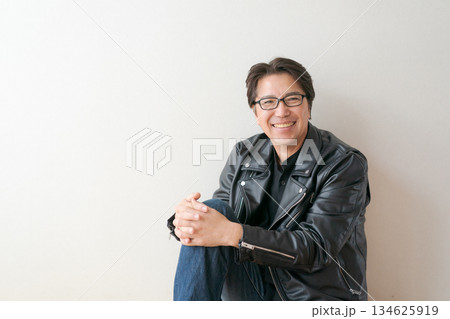 メガネをかけて革ジャンを着た50代男性 134625919