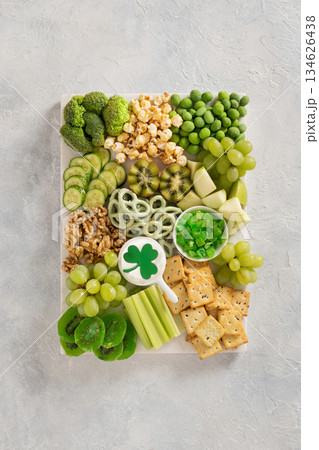 St Patricks day charcuterie board with green fruit and vegetables on light background. View from above. Festive holiday appetizer for celebration. 134626438