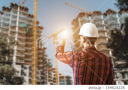 Engineer Architect Controlling Construction Process of Modern Building Site Engineer Architect Controlling Construction Process of Modern Building Site 134628226