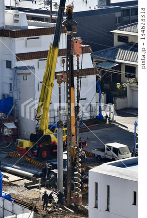 建設現場でコンクリート杭打ちする大型クレーン 134628318
