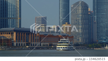 Modern ferry approaching waterfront with historical architectural contrast. Shanghai, China Modern ferry approaching waterfront with historical architectural contrast. Shanghai, China 134628515