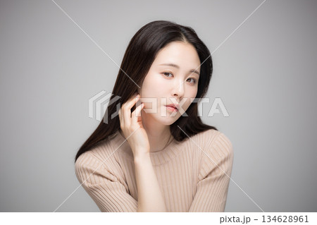 顎に手を当てて考えるアンニュイな表情の美人な女性　カメラ目線	 134628961