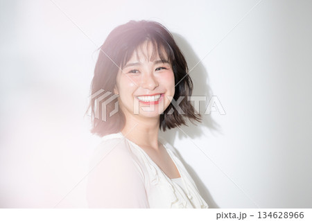 笑顔で喜ぶ透明感や多幸感あふれるハッピーな若い癒し系女性の美容イメージクローズアップ	 134628966