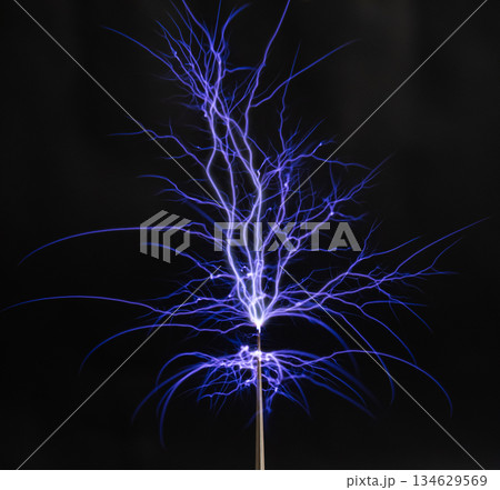 Spectacular electric arc discharge from a Tesla coil with branching sparks in the dark Spectacular electric arc discharge from a Tesla coil with branching sparks in the dark 134629569
