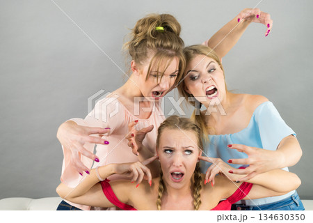 Woman being bullied by two females Woman being bullied by two females 134630350