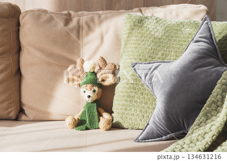 Cozy Living Room with Christmas Crocheted Reindeer Toy on Sofa with Sunlight Cozy Living Room with Christmas Crocheted Reindeer Toy on Sofa with Sunlight 134631216
