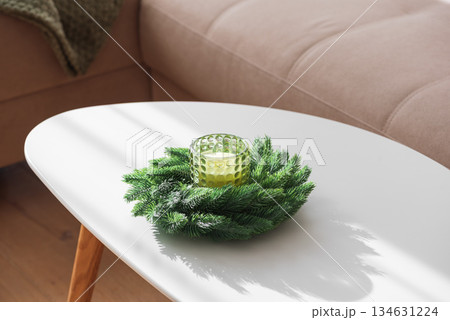 Cozy Living Room with Green Pillows, Knit Blanket, and Christmas Holiday Candle with Fir Wreath Cozy Living Room with Green Pillows, Knit Blanket, and Christmas Holiday Candle with Fir Wreath 134631224