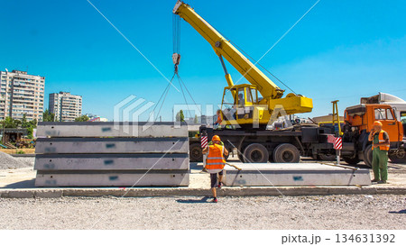Unloading concrete plates by crane at road construction site timelapse. Unloading concrete plates by crane at road construction site timelapse. 134631392
