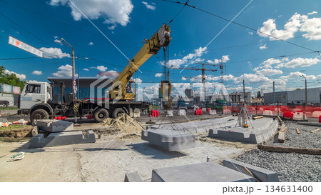 Installing concrete plates by crane at road construction site timelapse. Installing concrete plates by crane at road construction site timelapse. 134631400