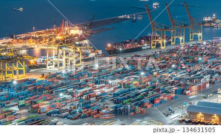 Seaport and loading docks at the port with cranes and multi-colored cargo containers day to night timelapse Seaport and loading docks at the port with cranes and multi-colored cargo containers day to night timelapse 134631505