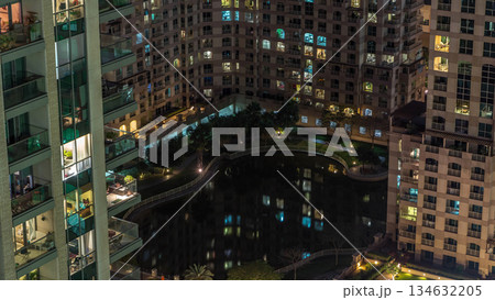 Manmade lake and residential buildings in Greens neighborhood night timelapse in Dubai, UAE 134632205