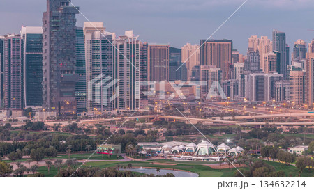 Jumeirah lake towers and Dubai marina skyscrapers and golf course night to day timelapse, Dubai, United Arab Emirates 134632214
