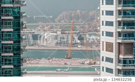 Aerial view to Dubai marina skyscrapers with construction site and Palm Jumeirah Island on background timelapse. Aerial view to Dubai marina skyscrapers with construction site and Palm Jumeirah Island on background timelapse. 134632256