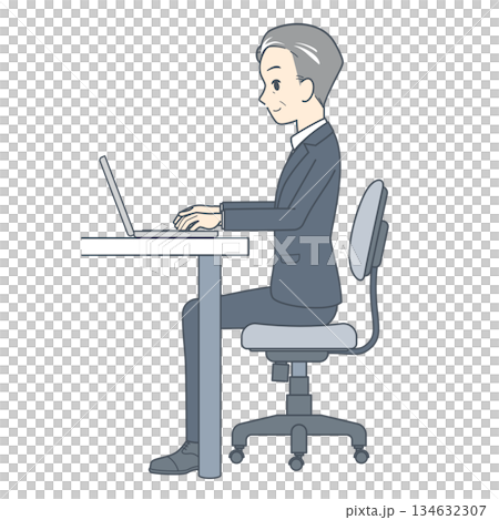 一位中年商務人士側身坐在辦公桌前，使用筆記型電腦工作。 134632307
