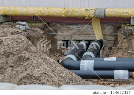 Insulated district heating pipes installation in deep urban trench Insulated district heating pipes installation in deep urban trench 134632357