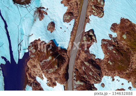 Top view of mountain road. The mountain is covered with melting snow. Abstract nature background Top view of mountain road. The mountain is covered with melting snow. Abstract nature background 134632888