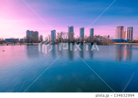 Kyiv in the morning. Left bank of the Dnieper River. Beautiful reflection of buildings in the lake Kyiv in the morning. Left bank of the Dnieper River. Beautiful reflection of buildings in the lake 134632994
