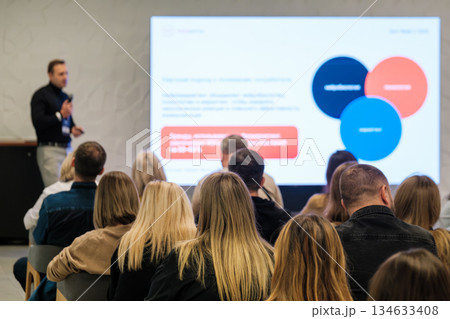 Professional speaker presents slide deck to attentive audience at a conference Professional speaker presents slide deck to attentive audience at a conference 134633408