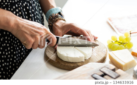 Girl Cutting Cheese On A Board For Cheese Board 134633916