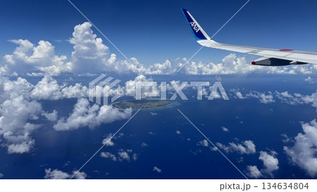 飛行機の窓から見た眼下に広がる海と陸と空の景色 飛行機の窓から見た眼下に広がる海と陸と空の景色 134634804