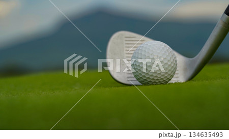 Golf clubs and golf balls on a green lawn in a beautiful golf course with morning sunshine. Golf clubs and golf balls on a green lawn in a beautiful golf course with morning sunshine. 134635493
