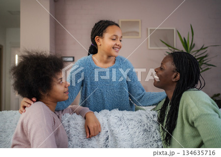African american mother and daughters laughing together at home African american mother and daughters laughing together at home 134635716
