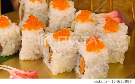 Delicious, fresh  sushi with bright orange tones presented on a traditional Japanese plate. 134635997