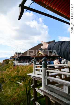 A man is pointing to the Kyoto city from kiyomizu-dera temple in Kyoto, Japan. Major tourist attraction in Kansai region in Japan. Travel concept. Japan cityscape. 134637314