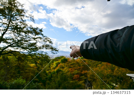 A man is pointing to the Kyoto city from kiyomizu-dera temple in Kyoto, Japan. Major tourist attraction in Kansai region in Japan. Travel concept. Japan cityscape. 134637315