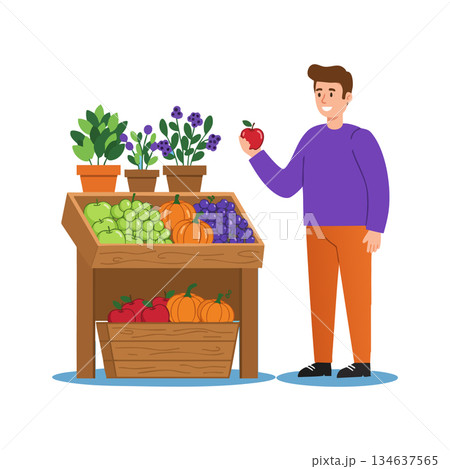 Man holding apple near fresh fruit and vegetable stand with pumpkins grapes and potted plants 134637565