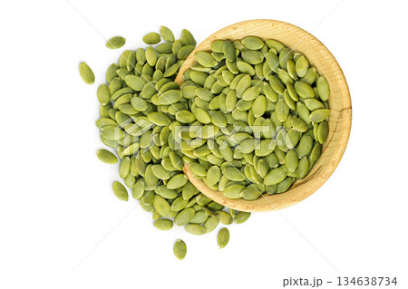 Peeled pumpkin seeds in wooden bowl isolated on white background. Top view. Flat lay Peeled pumpkin seeds in wooden bowl isolated on white background. Top view. Flat lay 134638734