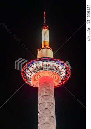 Low angle view of Kyoto Tower at night, Kyoto, Japan. Travel concept. Kyoto tower is the tallest building and a major tourist attraction in Kansai region in Japan. Low angle view of Kyoto Tower at night, Kyoto, Japan. Travel concept. Kyoto tower is the tallest building and a major tourist attraction in Kansai region in Japan. 134639122