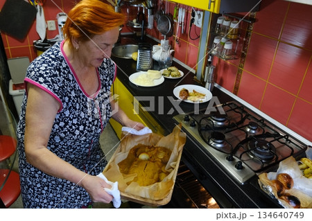 Senior woman cooking food on the stove in kitchen 134640749
