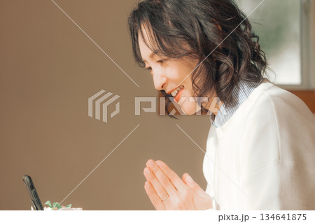 自宅で故人に祈りを捧げるミドル女性 134641875