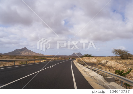 Off-road tourist car in the desert road and background two volcanic mountains Off-road tourist car in the desert road and background two volcanic mountains 134643787
