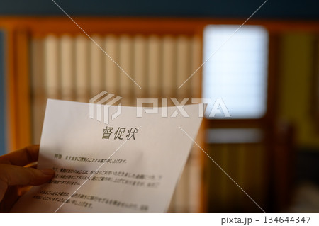 和室で督促状を持つ男性 134644347