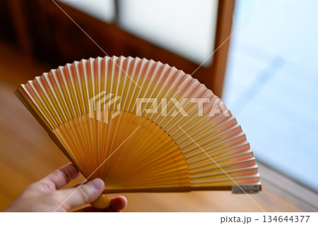 手に持つ和風の扇子 134644377