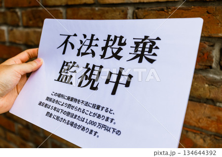 不法投棄監視中張り紙を持つ 134644392