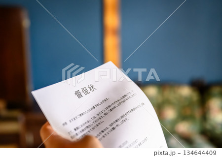 督促状を持つ手元 134644409