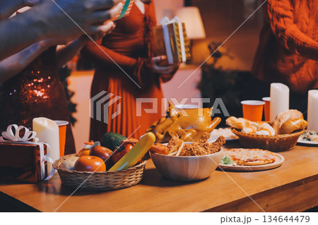 Festive Office Christmas Party with Delicious Food. A beautifully decorated office space with Christmas trees and festive lights, set up for a holiday party. 134644479