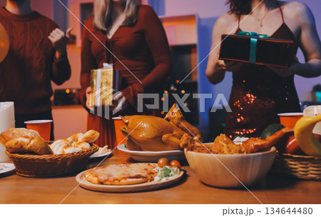 Festive Office Christmas Party with Delicious Food. A beautifully decorated office space with Christmas trees and festive lights, set up for a holiday party. 134644480