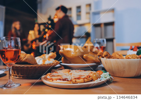 Festive Office Christmas Party with Delicious Food. A beautifully decorated office space with Christmas trees and festive lights, set up for a holiday party. 134646834