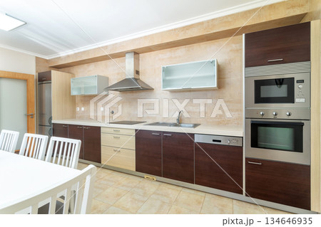 Bright and stylish kitchen features modern cabinets, sleek appliances, and ample workspace, perfect for cooking and entertaining in a family home Bright and stylish kitchen features modern cabinets, sleek appliances, and ample workspace, perfect for cooking and entertaining in a family home 134646935