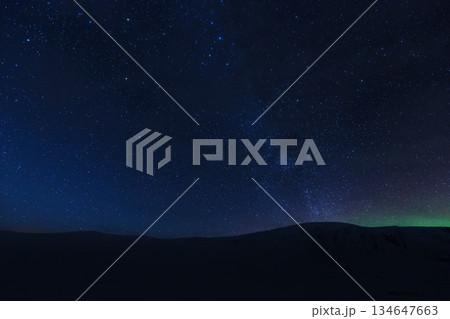 Starry night sky with Aurora over dark mountain Starry night sky with Aurora over dark mountain 134647663